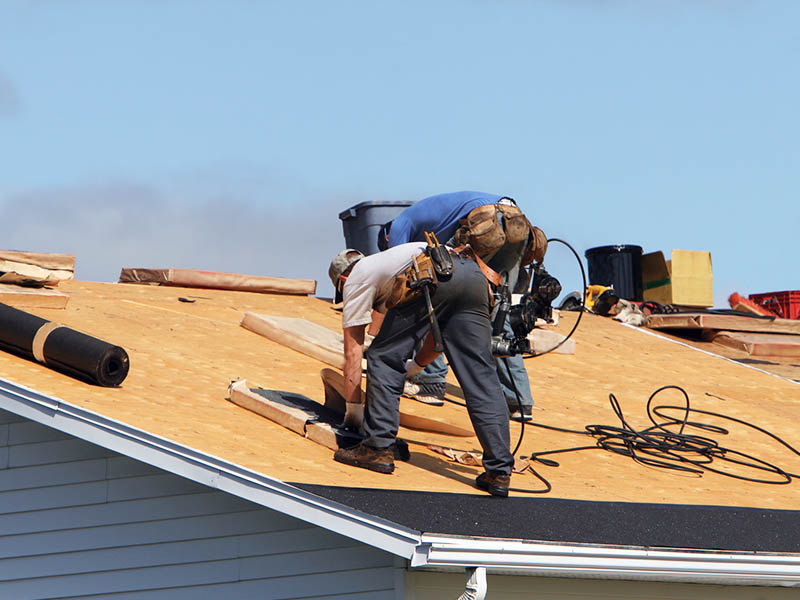 Roofers completing a residential roof replacement.
